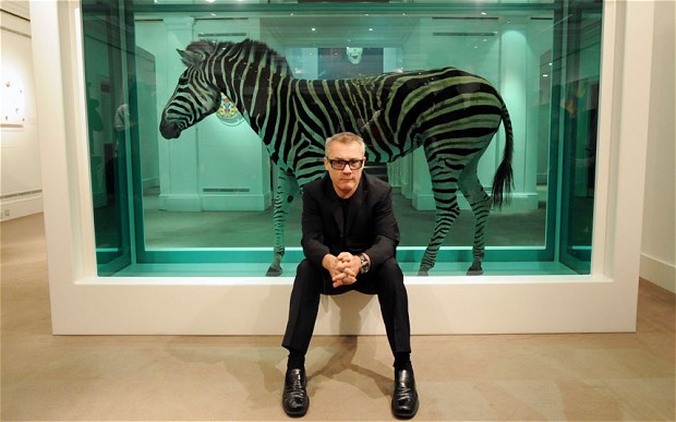 Damien Hirst poses in front of "The Incredible Journey" featuring a Zebra in formaldehyde.